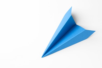 Photo of One handmade light blue paper plane on white background, top view. Space for text