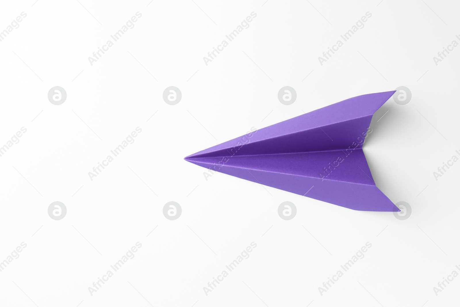 Photo of One handmade purple paper plane on white background, top view. Space for text