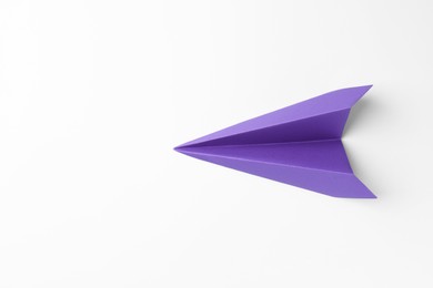 Photo of One handmade purple paper plane on white background, top view. Space for text