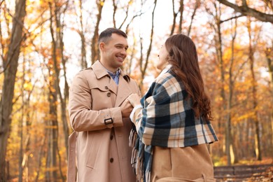 Happy couple spending time together in autumn park