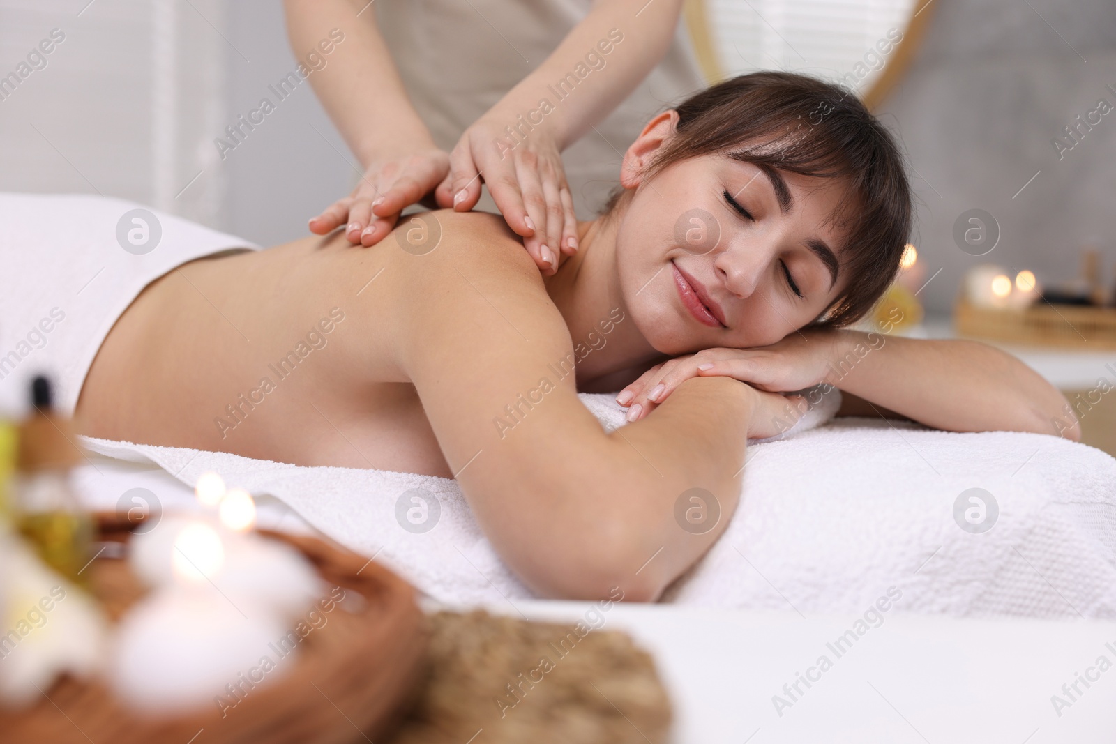 Photo of Young woman receiving massage in spa salon