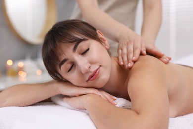 Photo of Young woman receiving massage in spa salon