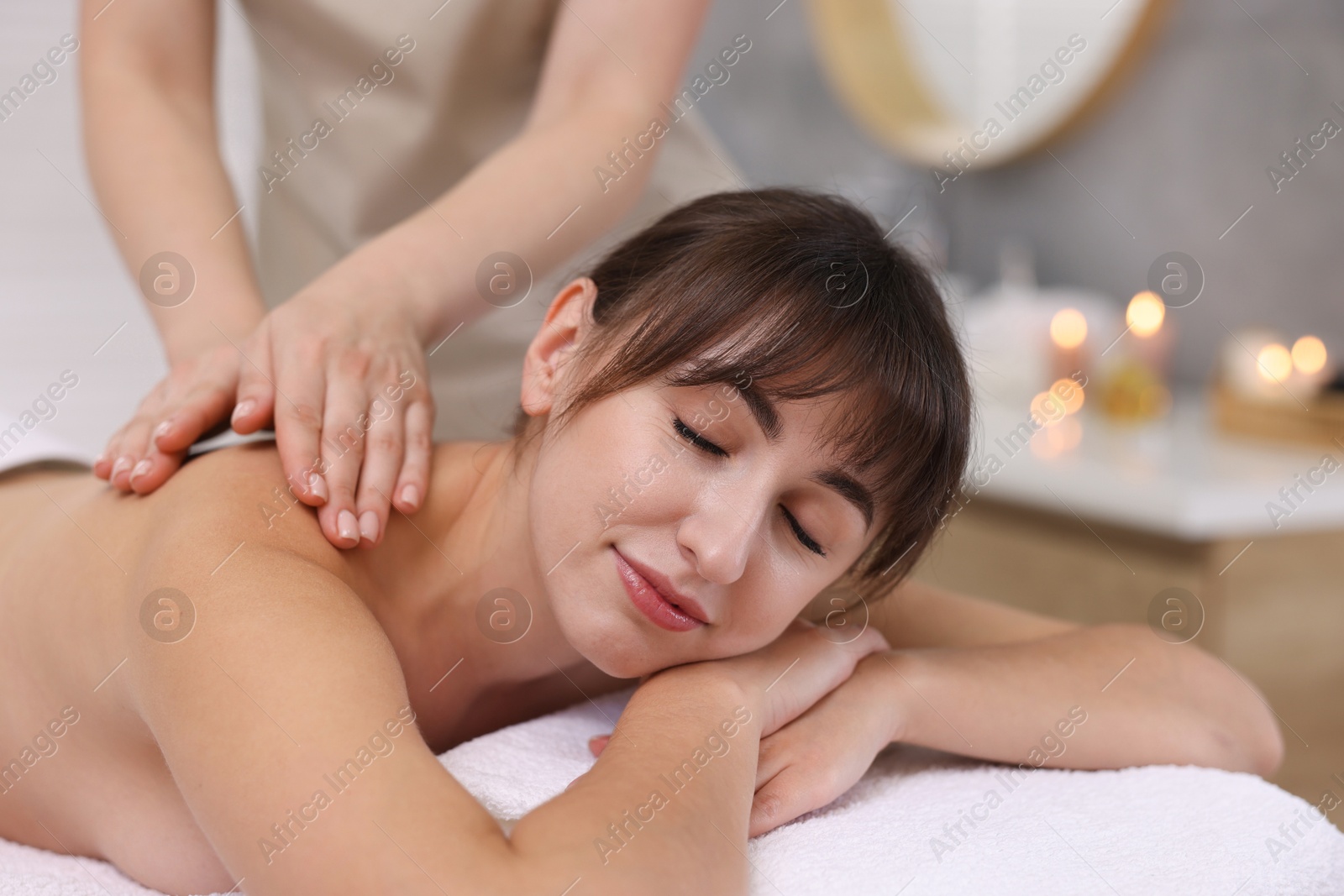 Photo of Young woman receiving massage in spa salon