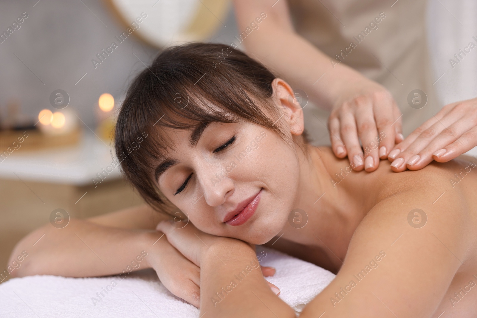 Photo of Young woman receiving massage in spa salon