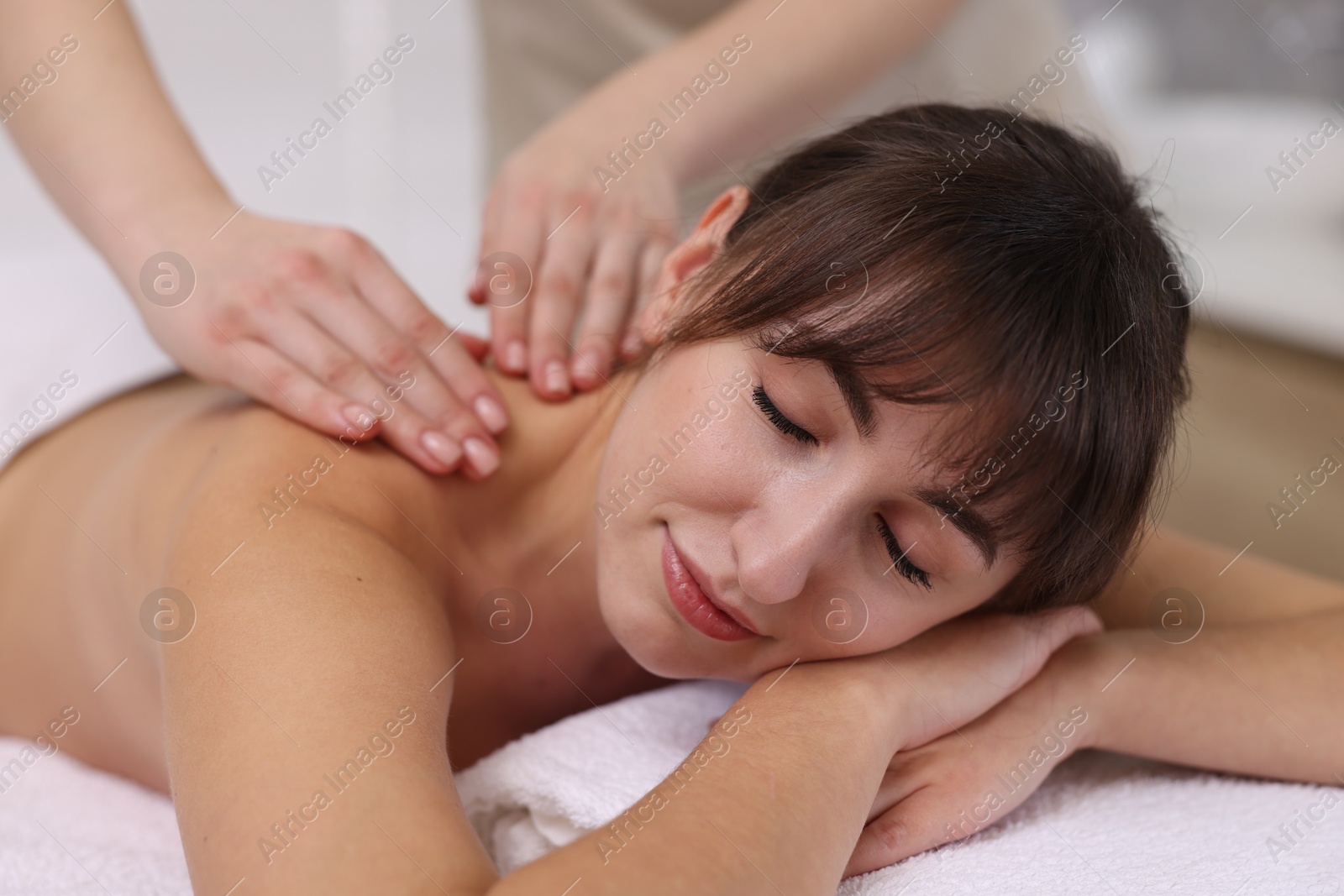 Photo of Young woman receiving massage in spa salon