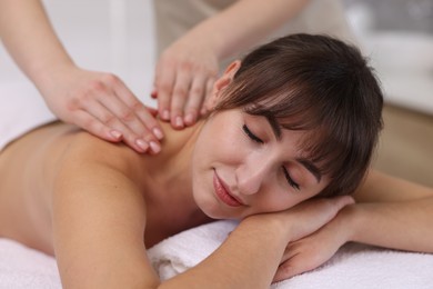 Photo of Young woman receiving massage in spa salon