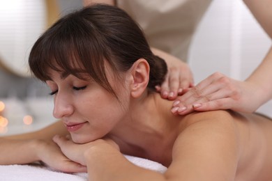 Photo of Young woman receiving massage in spa salon