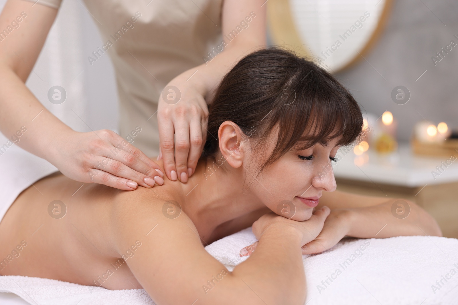 Photo of Young woman receiving massage in spa salon