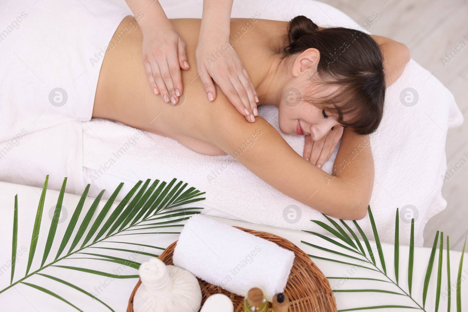 Photo of Young woman receiving massage in spa salon, top view