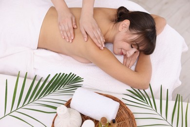 Young woman receiving massage in spa salon, top view