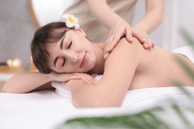 Photo of Young woman receiving massage in spa salon