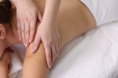 Photo of Young woman receiving massage in spa salon, closeup