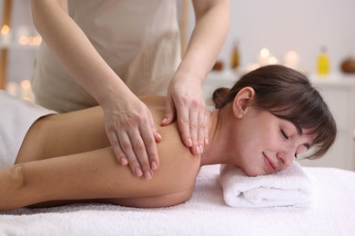 Photo of Young woman receiving massage in spa salon