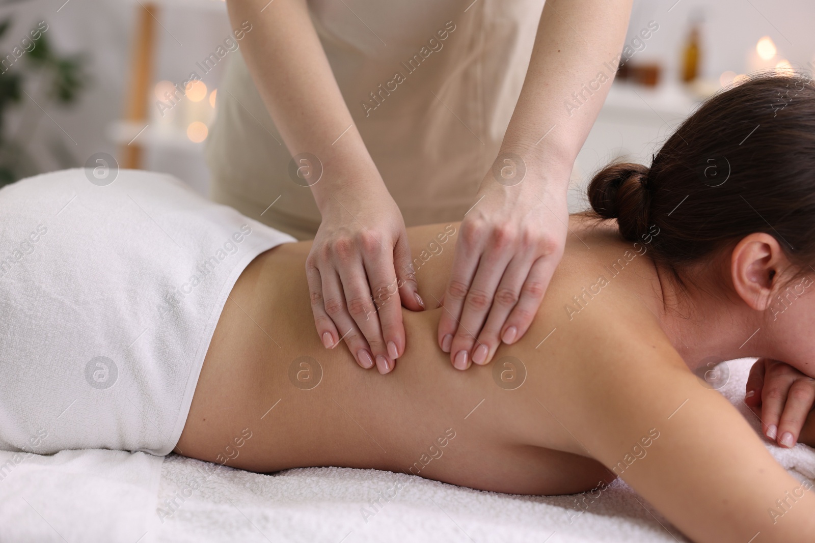 Photo of Young woman receiving massage in spa salon