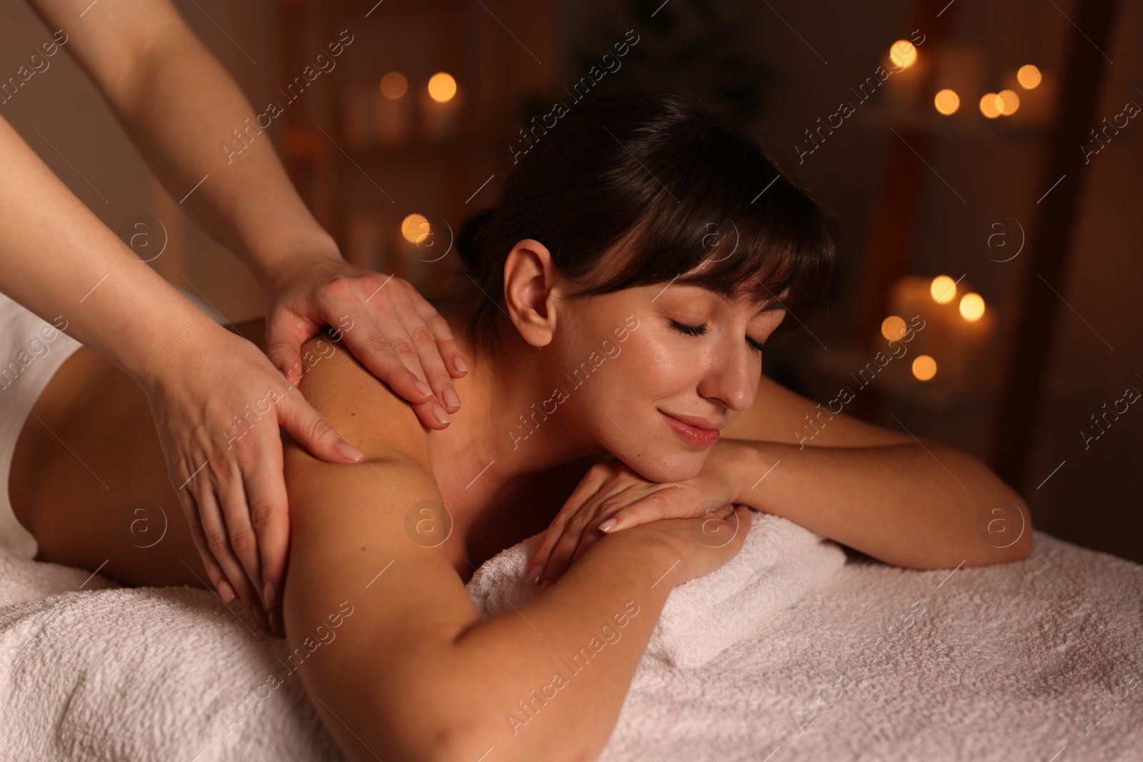 Photo of Young woman receiving massage in spa salon