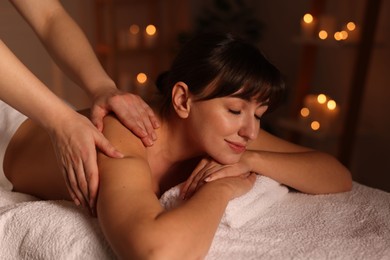 Photo of Young woman receiving massage in spa salon