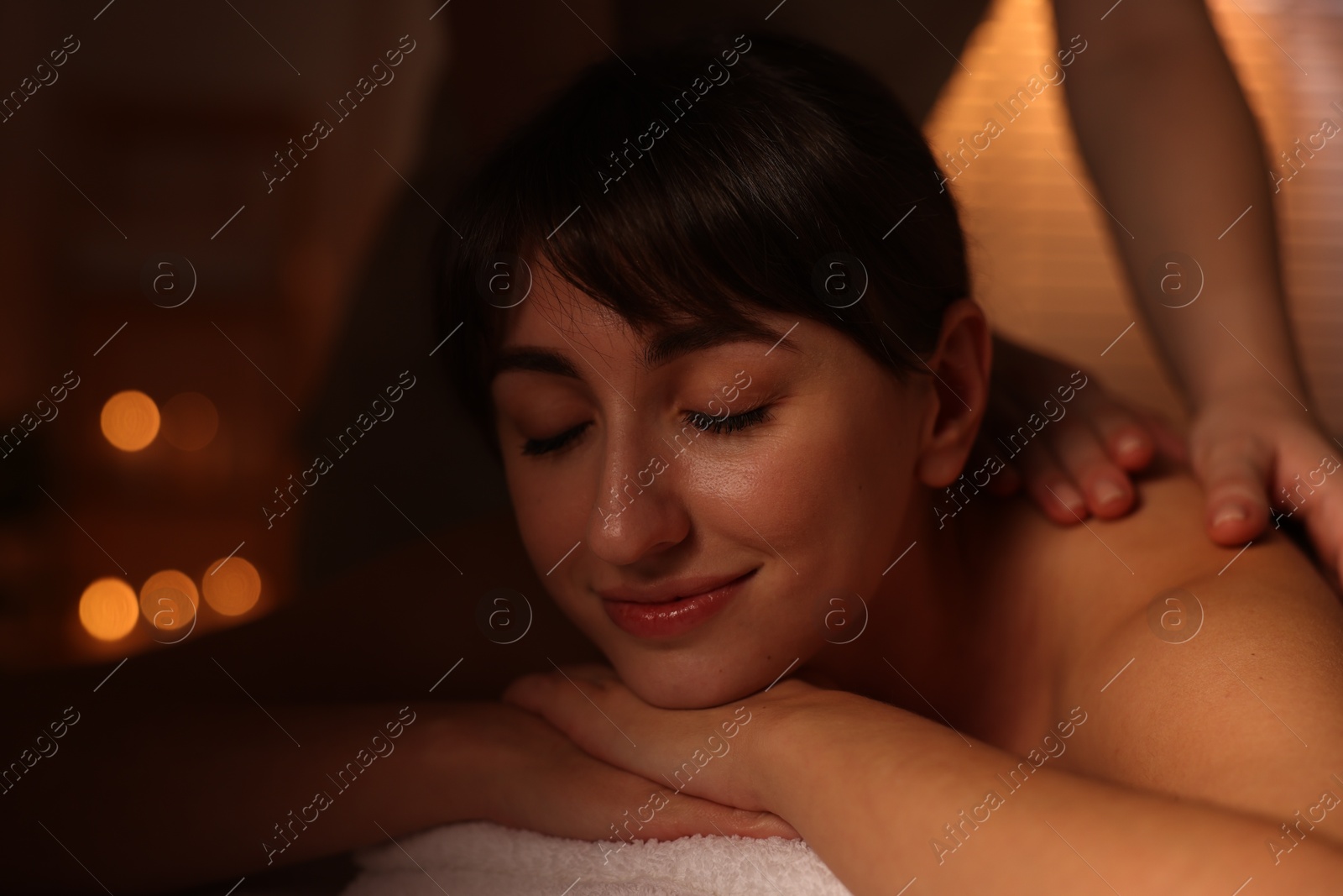 Photo of Young woman receiving massage in spa salon