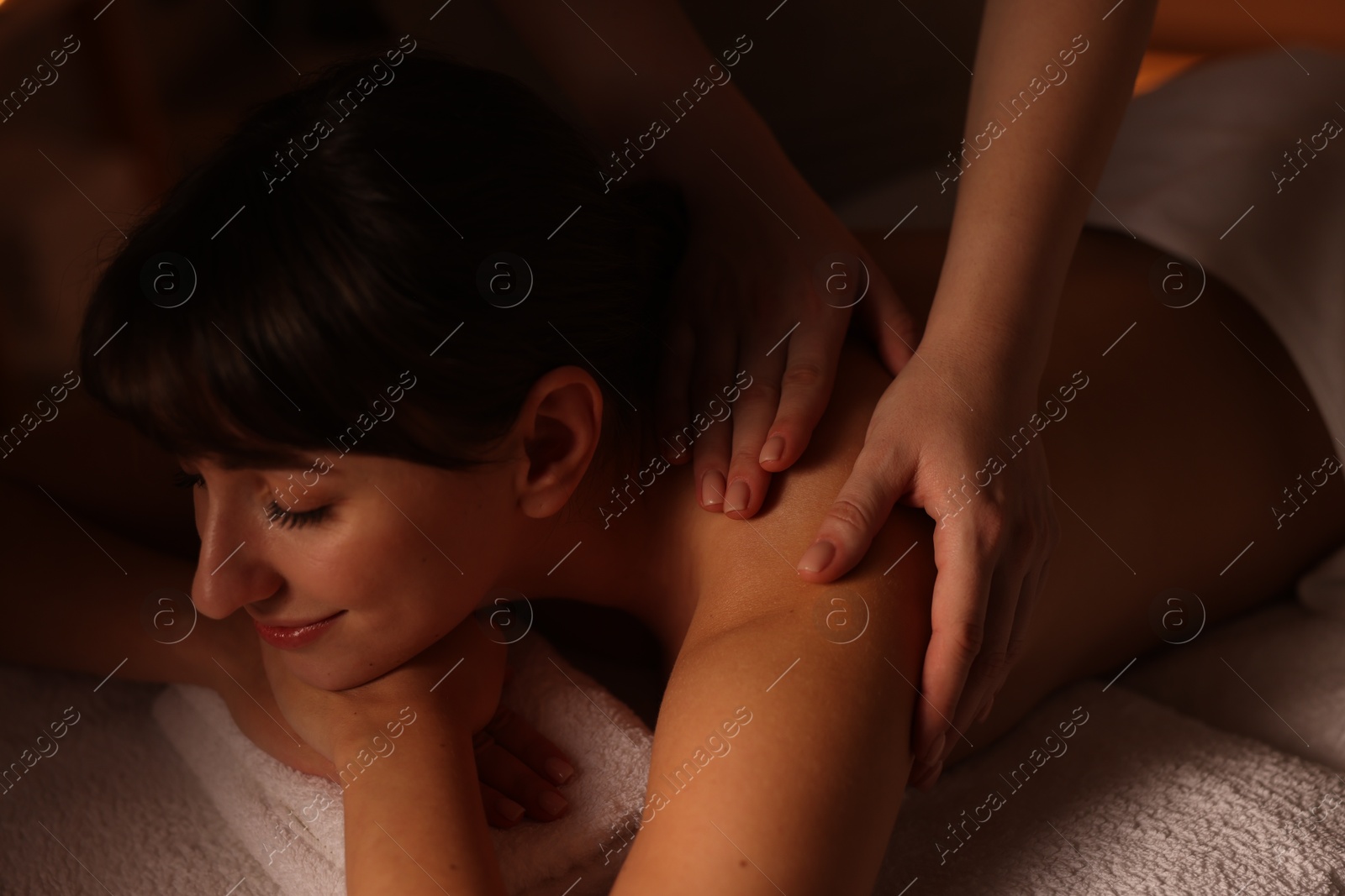 Photo of Young woman receiving massage in spa salon