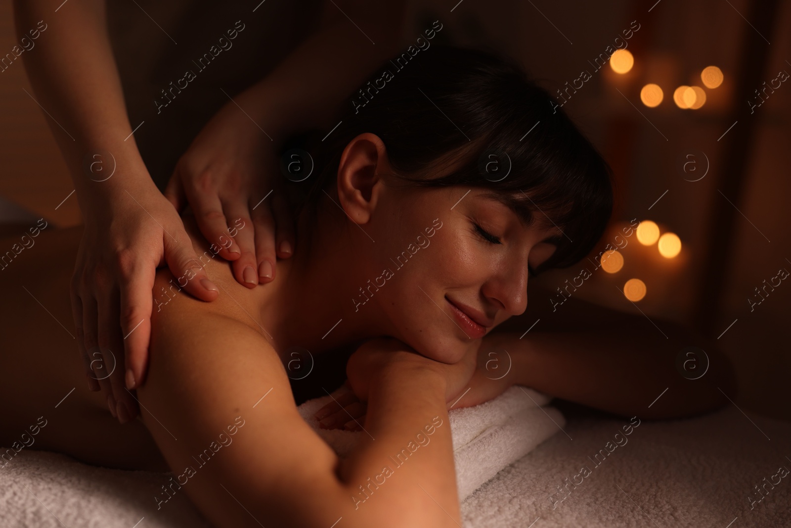 Photo of Young woman receiving massage in spa salon