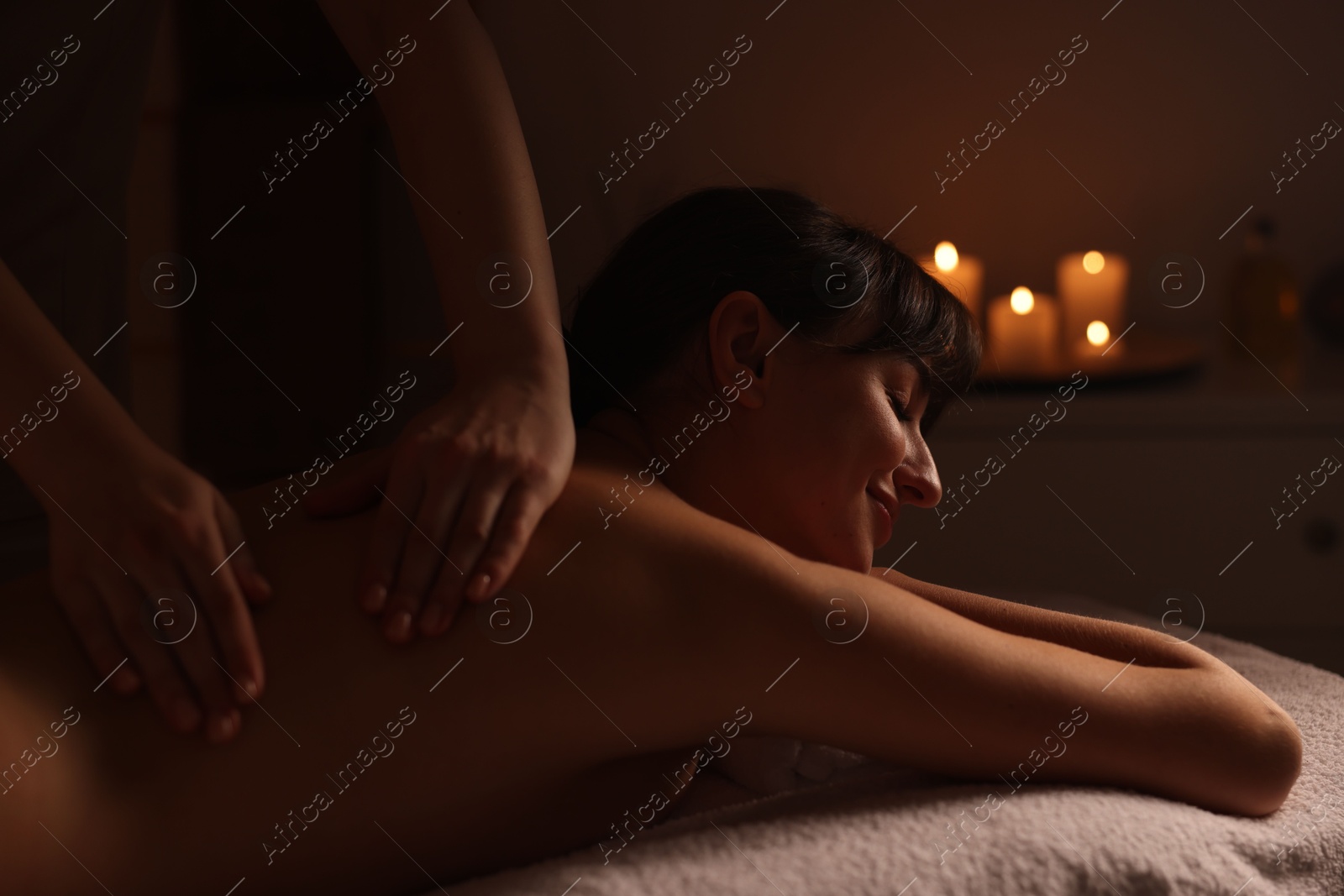 Photo of Young woman receiving massage in spa salon