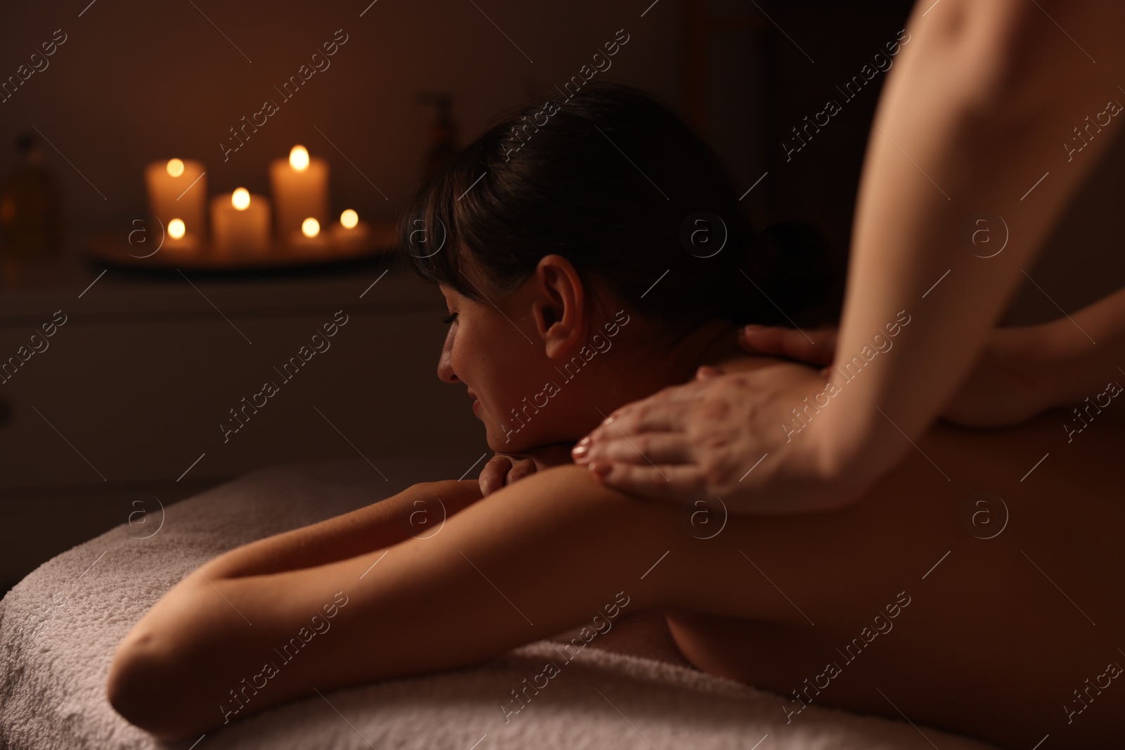 Photo of Young woman receiving massage in spa salon