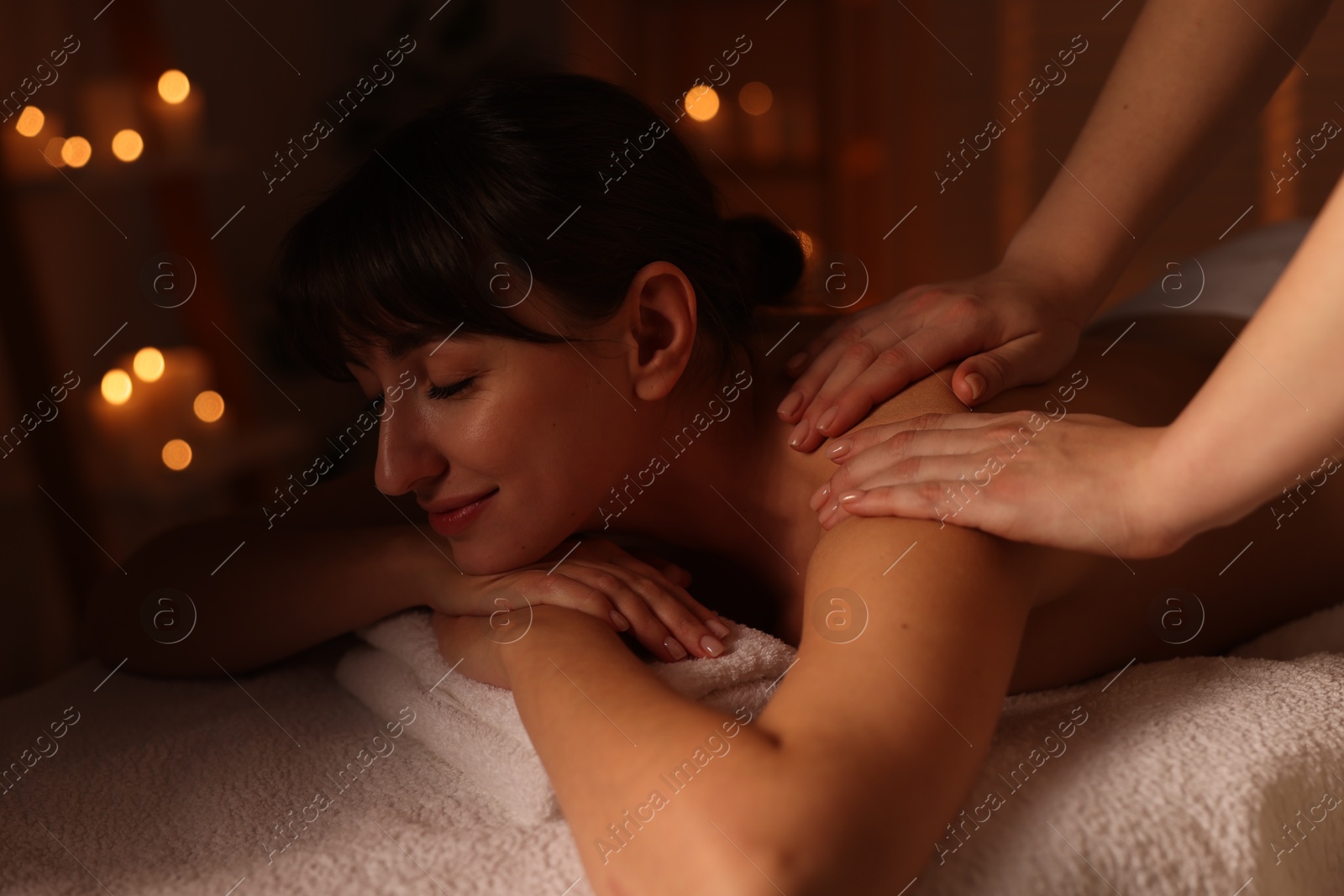 Photo of Young woman receiving massage in spa salon