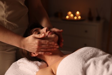 Photo of Young woman receiving massage in spa salon