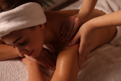 Photo of Young woman receiving massage in spa salon