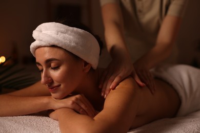 Photo of Young woman receiving massage in spa salon