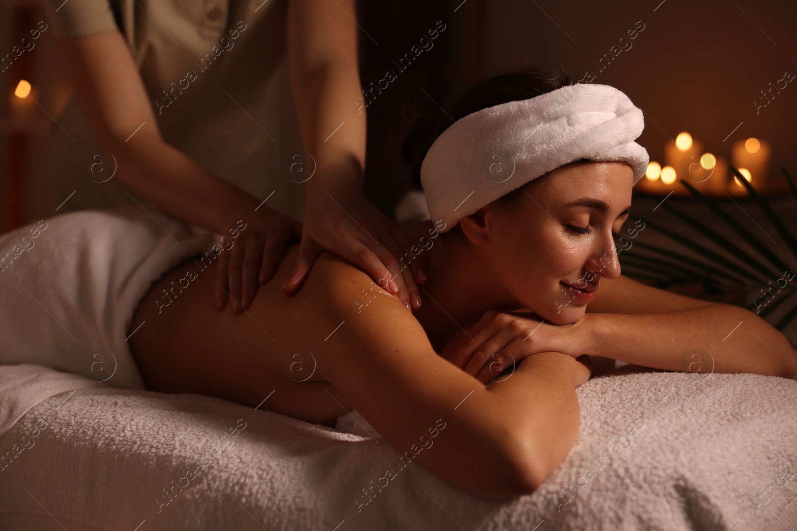 Photo of Young woman receiving massage in spa salon