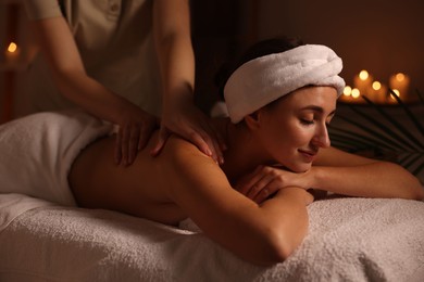 Photo of Young woman receiving massage in spa salon