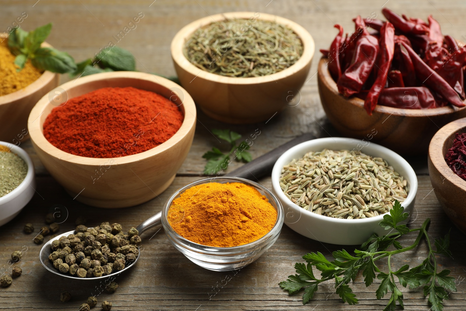 Photo of Different aromatic spices on wooden table, closeup