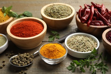 Photo of Different aromatic spices on wooden table, closeup