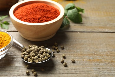 Photo of Aromatic spices on wooden table, closeup. Space for text