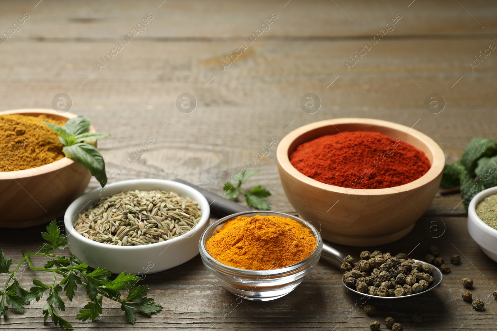 Photo of Different aromatic spices on wooden table, closeup. Space for text