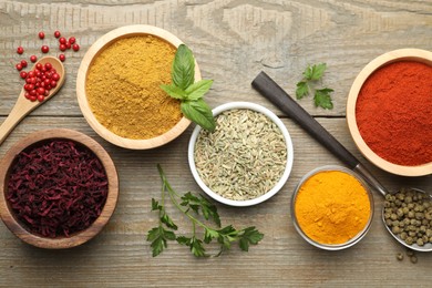 Photo of Different aromatic spices on wooden table, flat lay