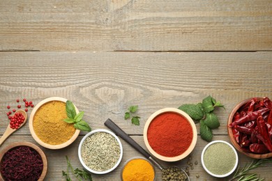 Photo of Different aromatic spices on wooden table, flat lay. Space for text