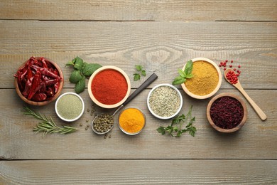 Photo of Different aromatic spices on wooden table, flat lay