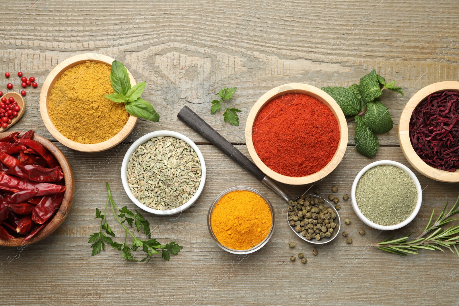 Photo of Different aromatic spices on wooden table, flat lay