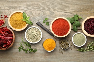 Photo of Different aromatic spices on wooden table, flat lay