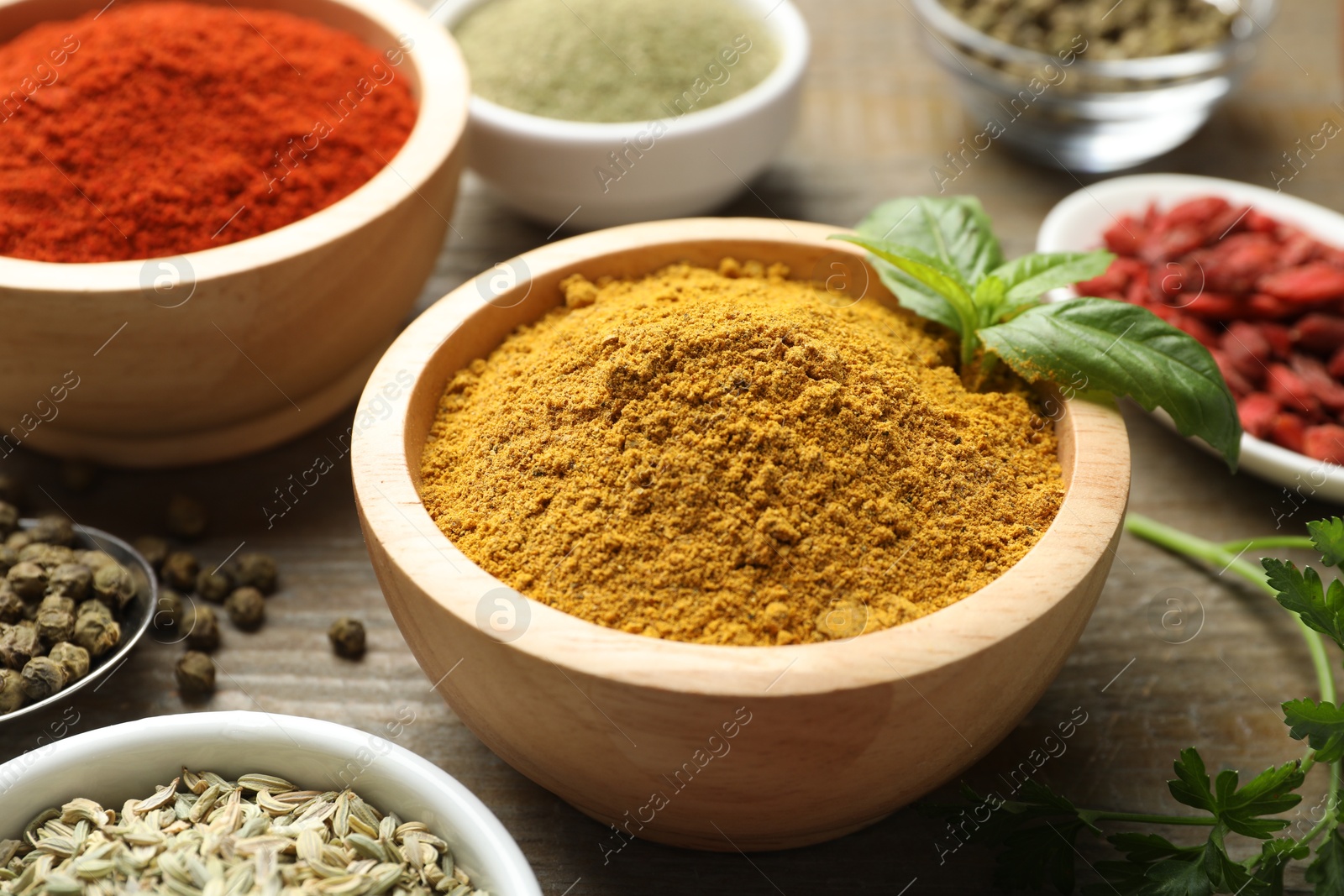 Photo of Different aromatic spices on wooden table, closeup