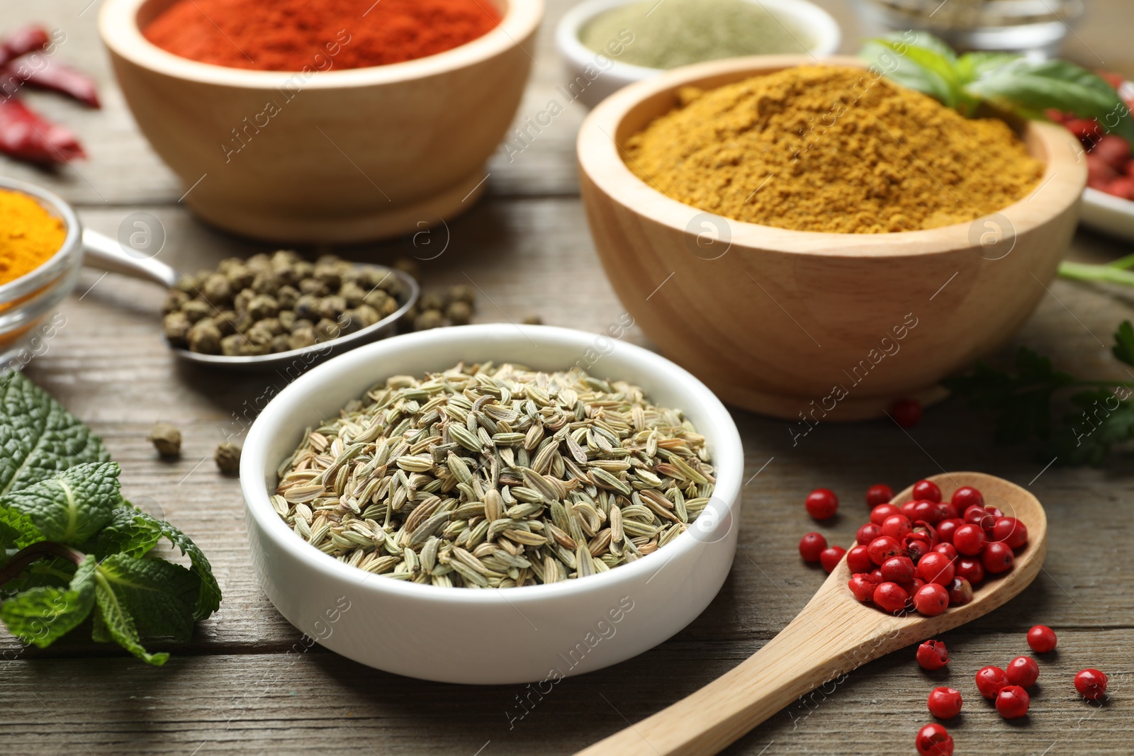 Photo of Different aromatic spices on wooden table, closeup