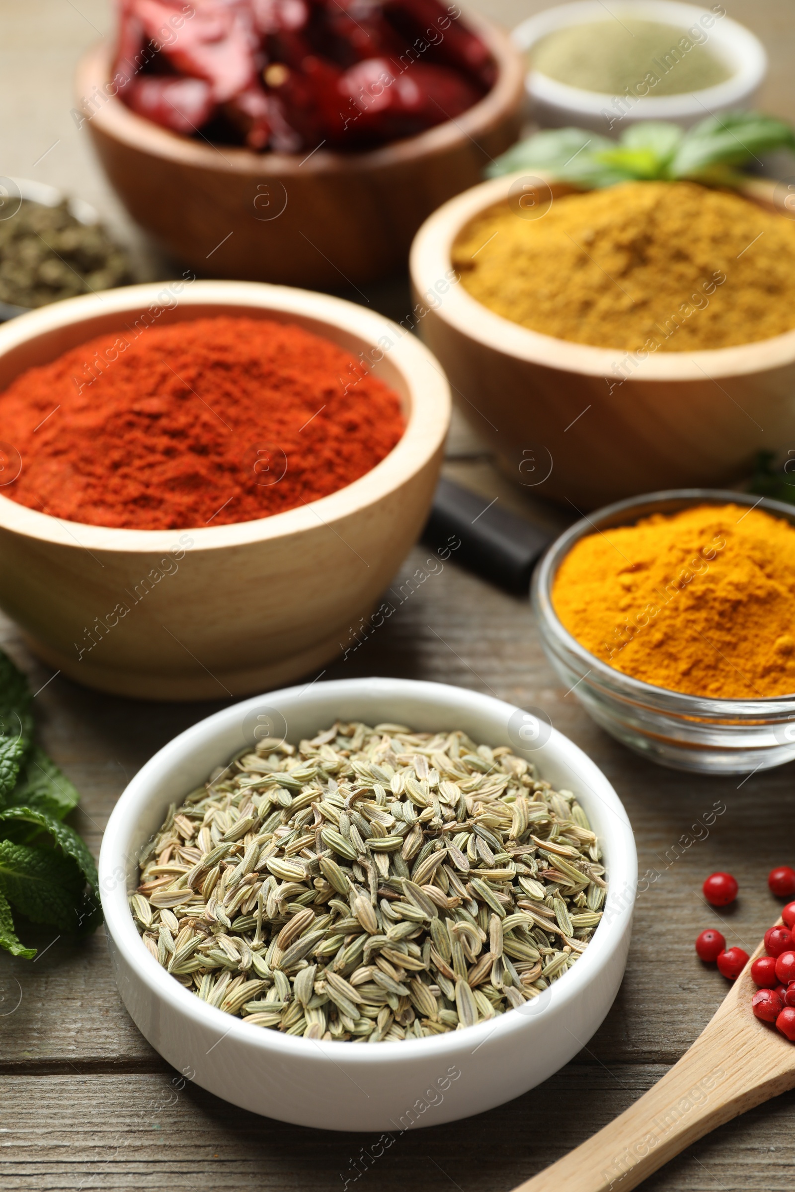 Photo of Different aromatic spices on wooden table, closeup