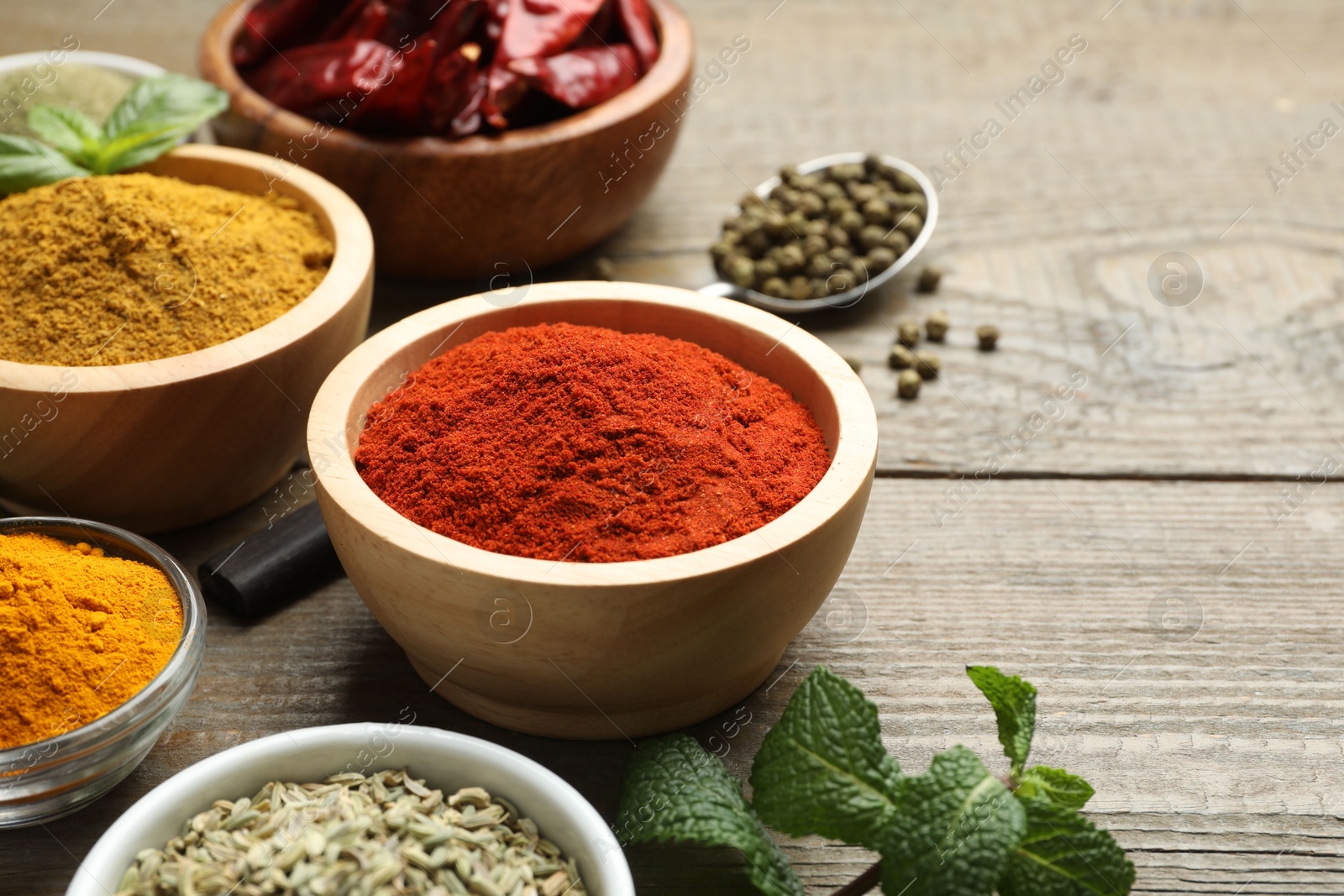 Photo of Different aromatic spices on wooden table, closeup