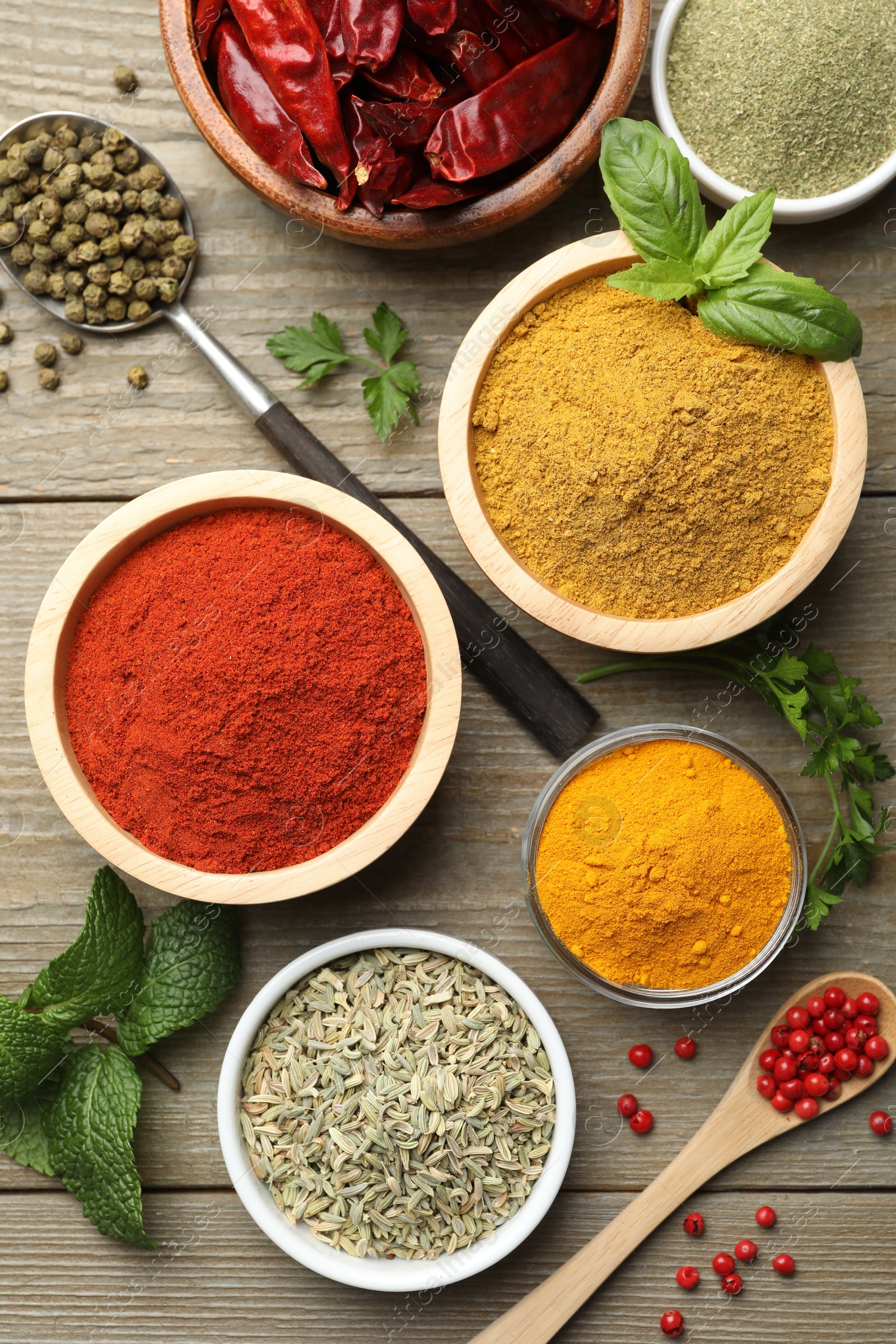 Photo of Different aromatic spices on wooden table, flat lay