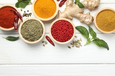 Photo of Different aromatic spices on white wooden table, flat lay. Space for text