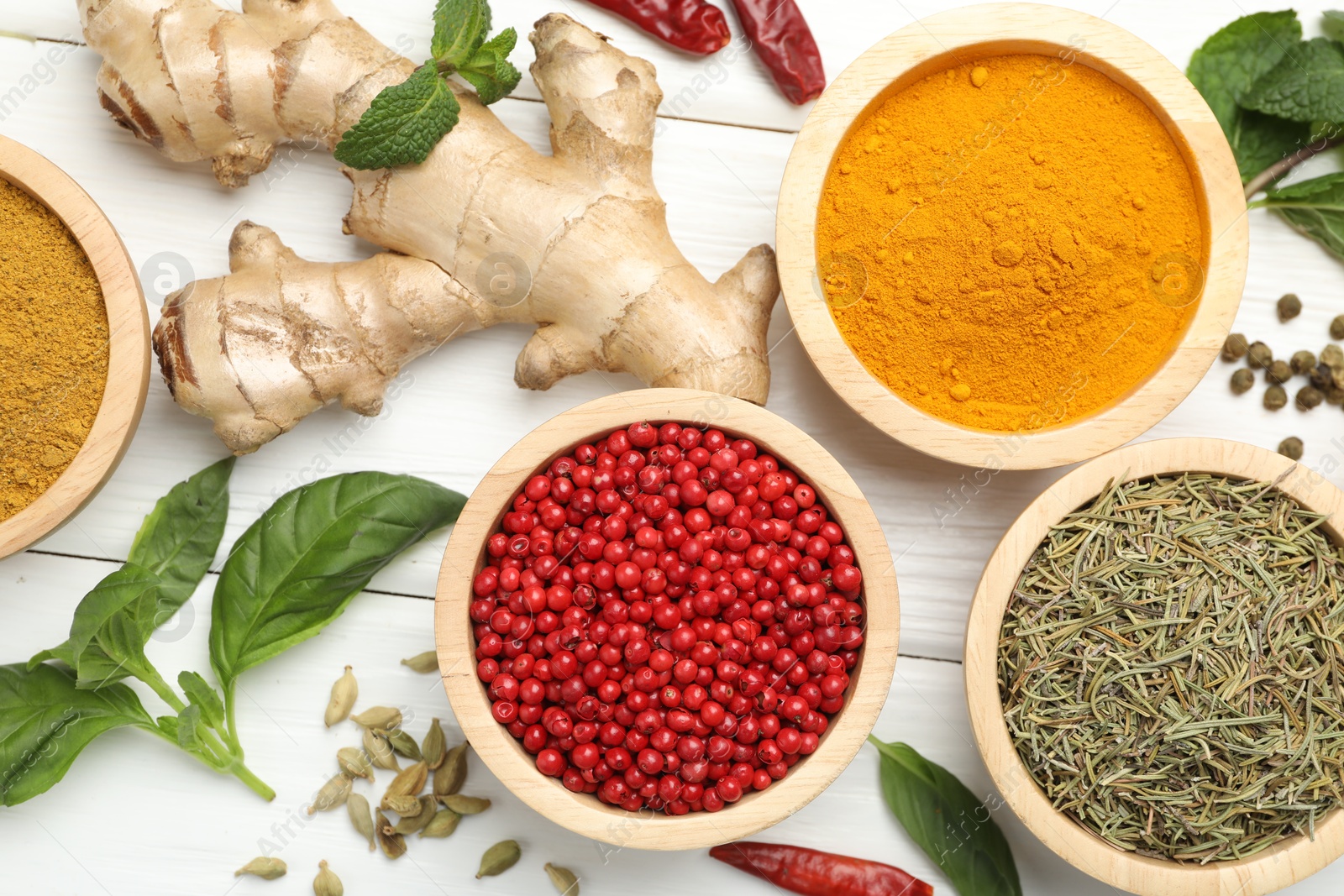 Photo of Different aromatic spices on white wooden table, flat lay