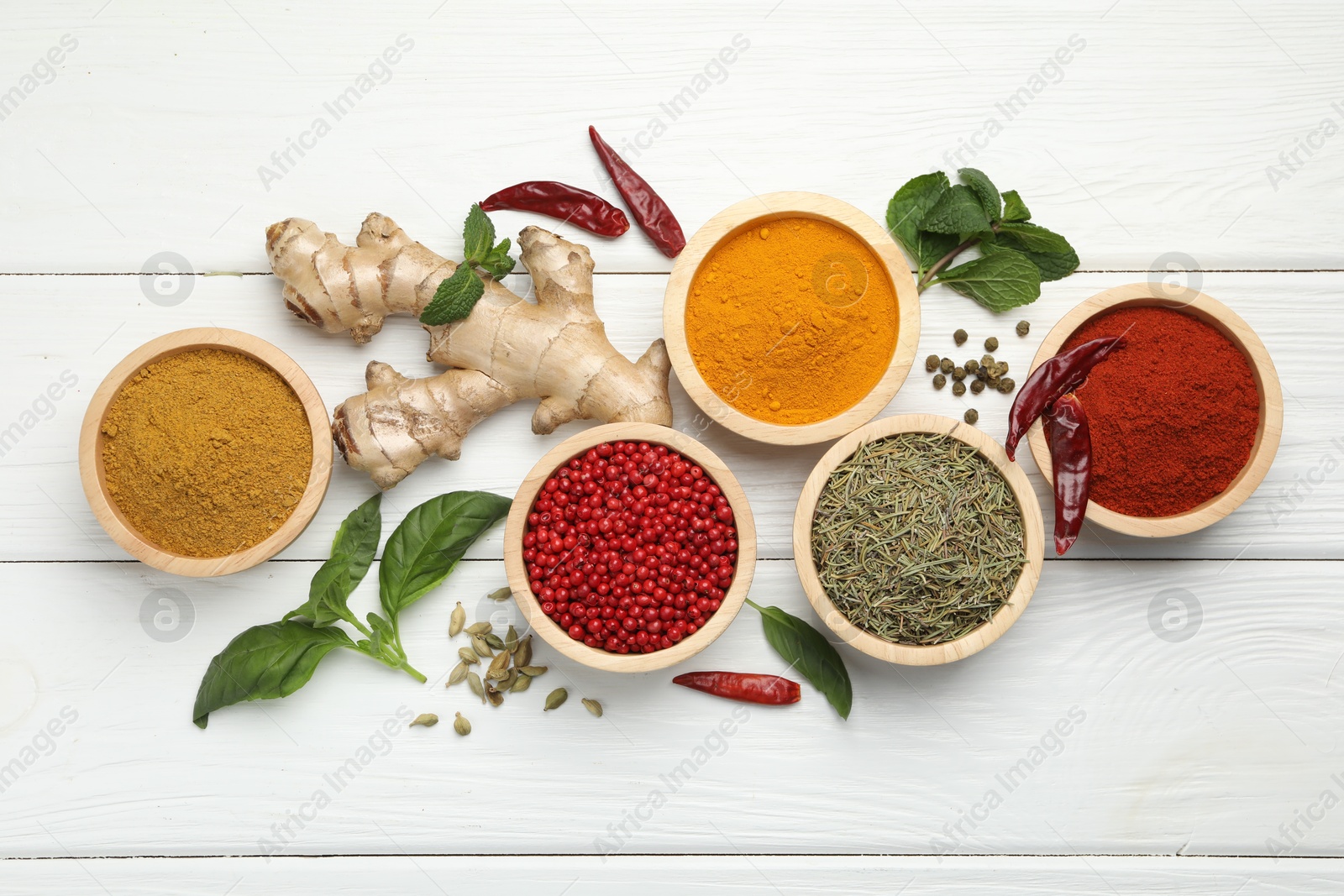 Photo of Different aromatic spices on white wooden table, flat lay