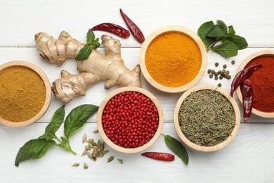 Photo of Different aromatic spices on white wooden table, flat lay