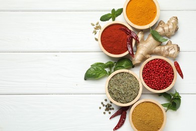 Photo of Different aromatic spices on white wooden table, flat lay. Space for text